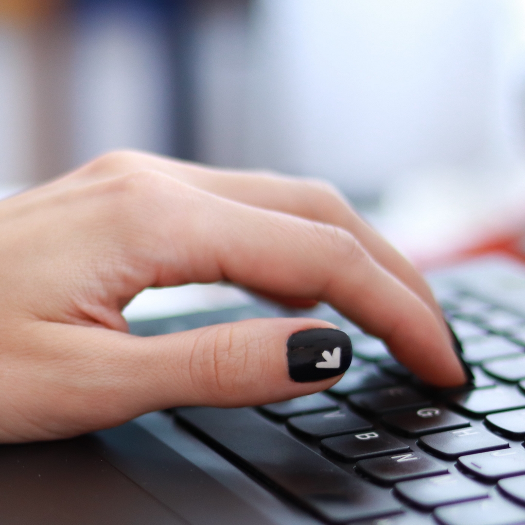 dłoń na klawiaturze laptopa